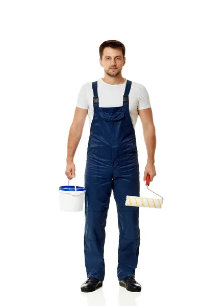 Repairman holding paint roller and can with paint. — Stock Photo, Image