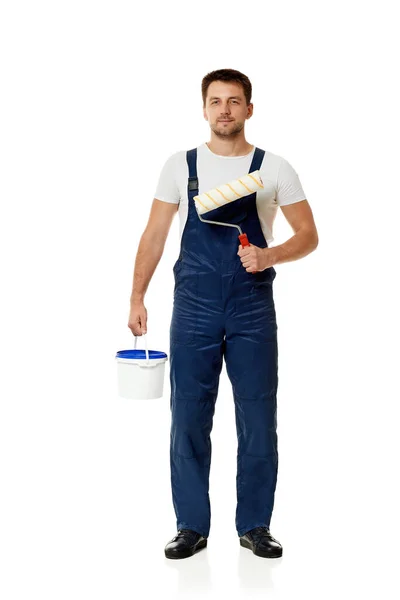 Repairman holding paint roller and can with paint. — Stock Photo, Image