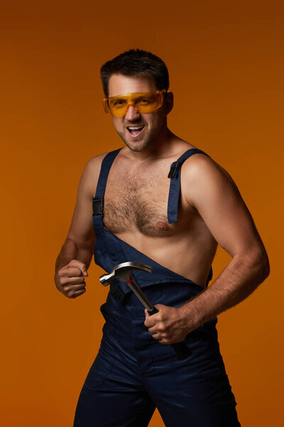 сексуальный кавказский рабочий в форме с молотком в руках