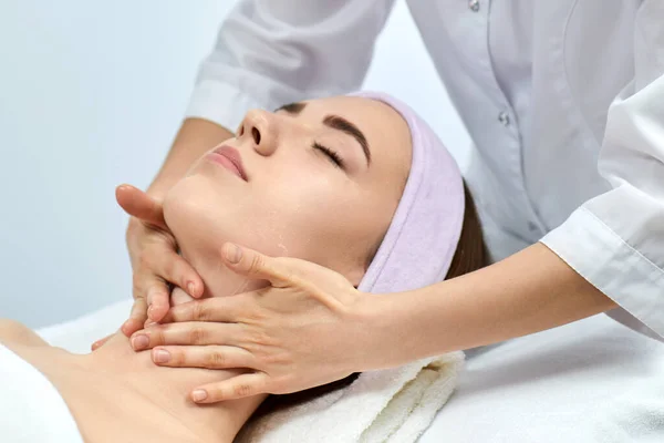 Jovem bela mulher recebendo a massagem facial — Fotografia de Stock