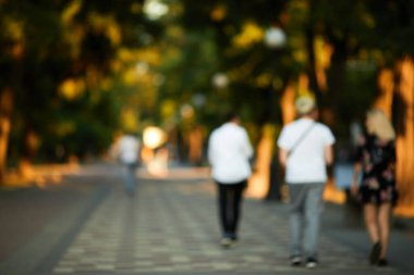 Bulanık insanlar güneşli sokakta yürüyor