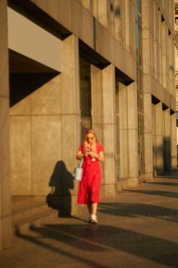 Şehrin güneşli sokaklarında yürüyen insanlar.