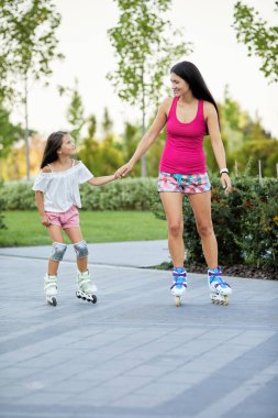 Genç anne ve küçük kızı paten kayıyor.