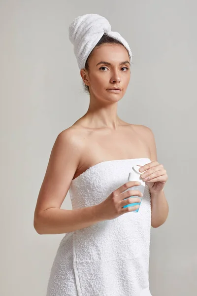 Woman holds tonic to remove makeup. — Stock Photo, Image