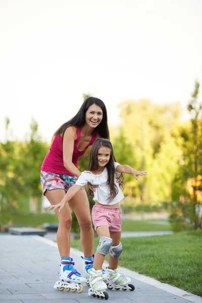 Mother and her little daughter rollerskating — Stock Photo, Image