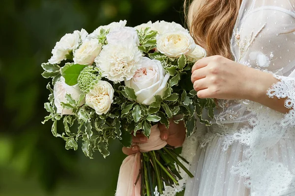Elegante bruid houdt witte bruiloft bloem boeket — Stockfoto