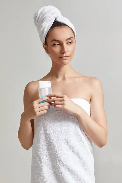 Woman holds tonic to remove makeup. — Stock Photo, Image