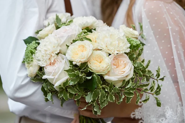 A menyasszony és a vőlegény fehér virágcsokrot tart. — Stock Fotó