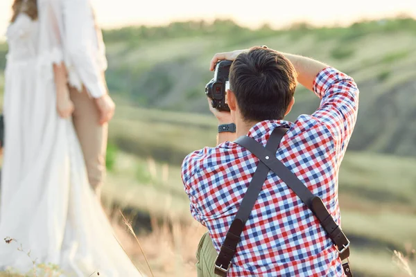 Düğün fotoğrafçısı gelin ve damadın fotoğraflarını çeker. — Stok fotoğraf