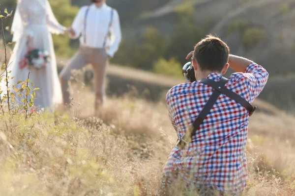 Bröllopsfotograf tar bilder av brud och brudgum — Stockfoto