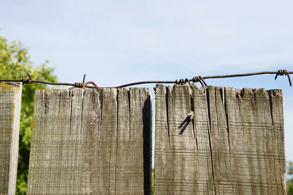 Dikenli tel ile ahşap çit.