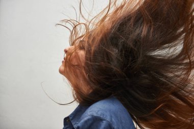 Saçları rüzgarla sallanan bir modelin güzel fotoğrafı.