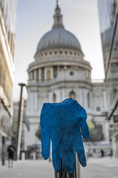 ロンドンの通りに捨てられた青いプラスチック製の手袋を背景に聖パウルス大聖堂 — ストック写真
