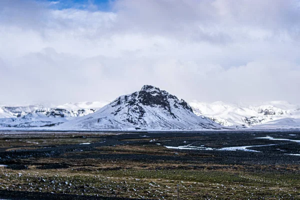 Foto Uma Paisagem Nevada Com Uma Montanha Incrível Islândia Durante — Fotografia de Stock