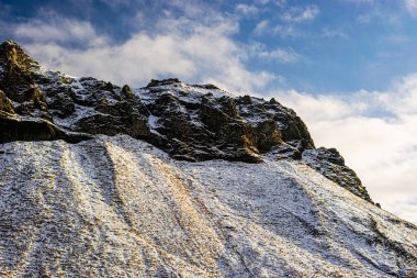 İzlanda 'da güneşli bir günde karlı bir kayanın fotoğrafı. Etkileyici İzlanda manzarası
