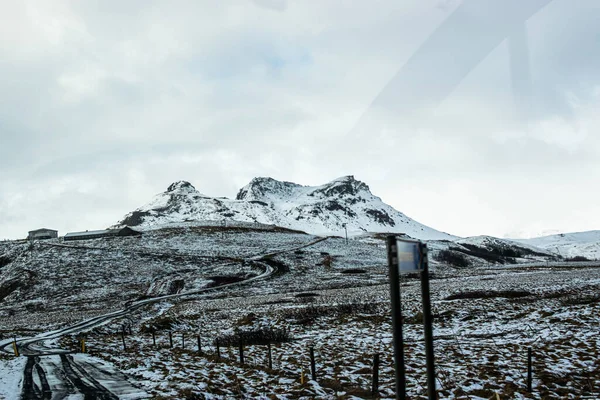 Foto Uma Paisagem Nevada Com Uma Montanha Incrível Islândia Durante — Fotografia de Stock