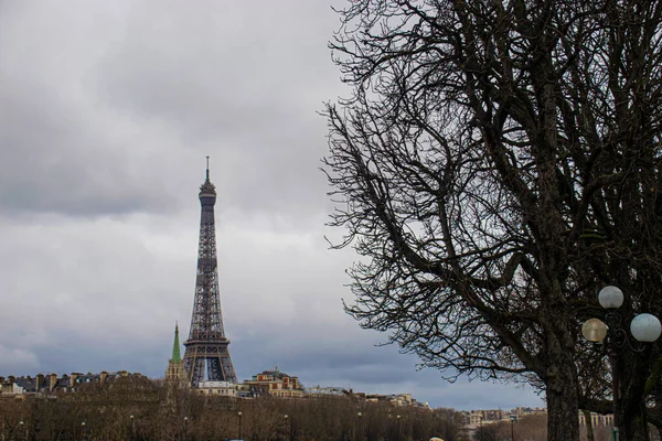 Photo of the Eiffel tower from the other side of the river during a cloudy day of winter