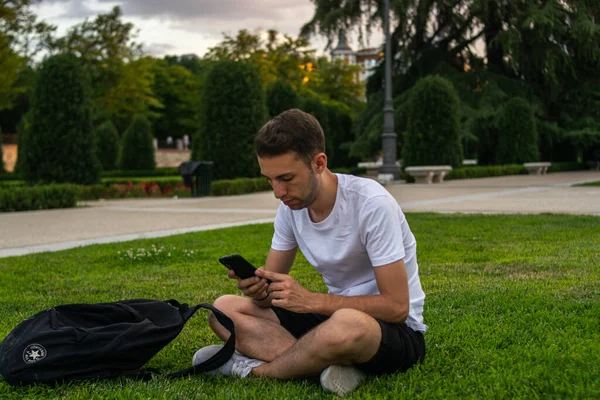 Photo Jeune Séduisant Homme Avec Shirt Blanc Assis Sur Herbe — Photo