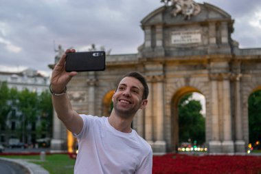 Madrid, İspanya / 13 Temmuz 2020 / Gün batımında Madrid 'de Alcala kapısının yanında çekici bir adamın fotoğrafı