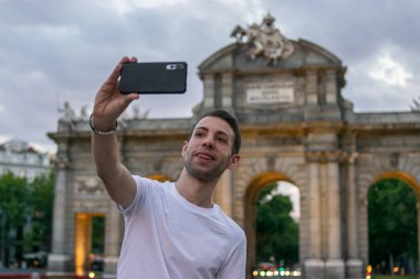 Madrid, İspanya / 13 Temmuz 2020 / Gün batımında Madrid 'de Alcala kapısının yanında çekici bir adamın fotoğrafı