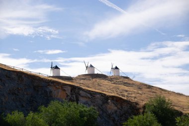 Güneşli bir yaz gününde İspanya 'nın Consuegra kentindeki bazı güzel ve tarihi yel değirmenlerinin fotoğrafı.. 