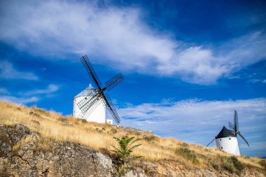 Güneşli bir yaz gününde İspanya 'nın Consuegra kentindeki bazı güzel ve tarihi yel değirmenlerinin fotoğrafı.. 