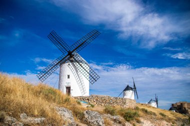 Güneşli bir yaz gününde İspanya 'nın Consuegra kentindeki bazı güzel ve tarihi yel değirmenlerinin fotoğrafı.. 