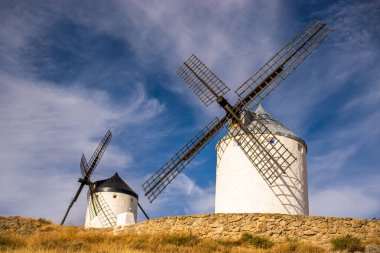 Güneşli bir yaz gününde İspanya 'nın Consuegra kentindeki bazı güzel ve tarihi yel değirmenlerinin fotoğrafı.. 