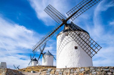 Güneşli bir yaz gününde İspanya 'nın Consuegra kentindeki bazı güzel ve tarihi yel değirmenlerinin fotoğrafı.. 
