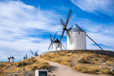 Güneşli bir yaz gününde İspanya 'nın Consuegra kentindeki bazı güzel ve tarihi yel değirmenlerinin fotoğrafı.. 