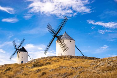 Güneşli bir yaz gününde İspanya 'nın Consuegra kentindeki bazı güzel ve tarihi yel değirmenlerinin fotoğrafı.. 