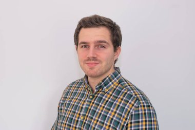 Kameraya gülümseyen ve tişört giyen genç ve çekici bir adamın fotoğrafı çok profesyonel görünüyor. Sıradan bir iş adamı, şirket adamı..