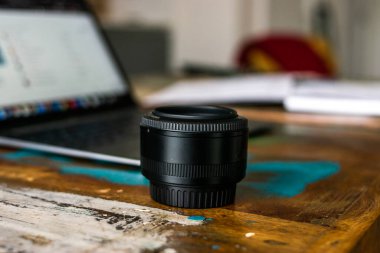 Telefonunu kontrol eden genç ve çekici bir iş adamının fotoğrafı. Koronavirüs salgını sırasında şık kıyafetler ve beyaz bir maske takıyor.