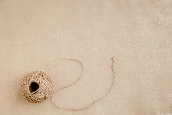 Üst görünüm moda tasarımcısı arka plan konsepti. Ev ofis masası stüdyosundaki modern kahverengi keten kumaşın üzerine sicim serpiştirme aksesuarı düzleştirildi. Yaratıcı tasarım için alan oluşturuldu..
