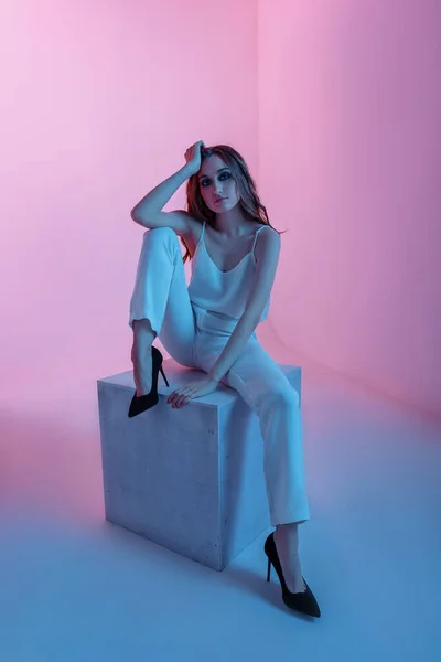 Moda. Renkli neon ışıklı kadın. Beyaz kostümlü seksi kız, makyaj dansı. Parti disko neon gece kulübü titreşimleri. Moda model portre, yaratıcı sanat neon pembe ışık, pankart.
