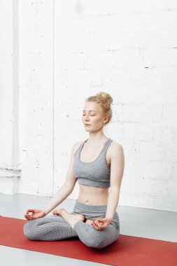 Genç bir kadın yoga yapıyor. Yoga stüdyoda..