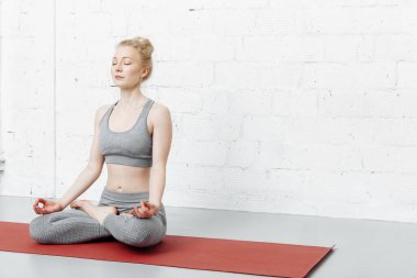 Genç bir kadın yoga yapıyor. Yoga stüdyoda..