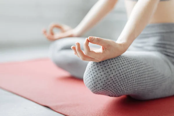 Meditasyon konsepti. Yogada bacak bacak üstüne atmış genç ofis Yogi kadınının ellerini kapat. Pembe mindere kolay poz ver, Jnana Mudra 'da parmaklarıyla meditasyon yap.