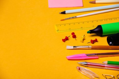 Okul gereçleri ve aksesuarlar sarı arka planda. Metin için yerinizi söyleyin..