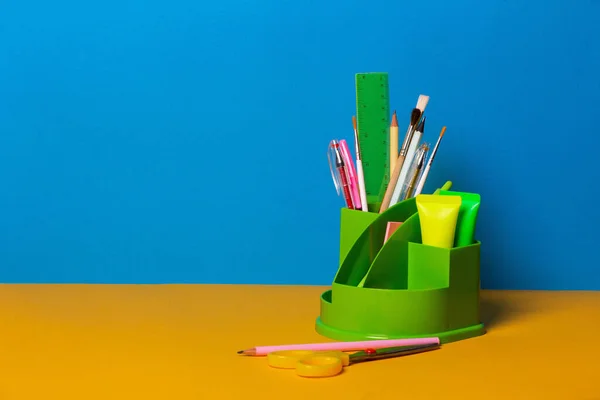 Sarı ve mavi arka planda okul araçları ve aksesuarları