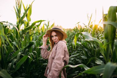 Mısır tarlasında hasır şapkalı bir kız.