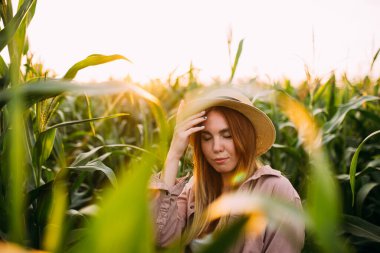 Mısır tarlasında hasır şapkalı bir kız.