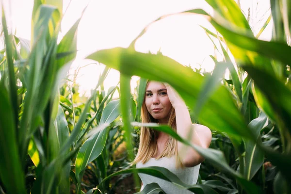 Kızıl saçlı kız mısır tarlasında gülümsüyor.