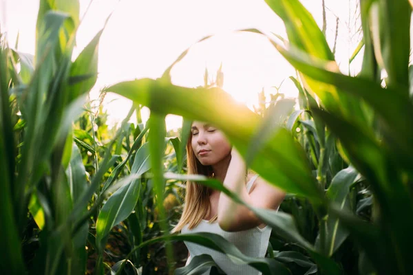 Kızıl saçlı kız mısır tarlasında gülümsüyor.