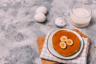 Krepler, yumurtalar, bal, gri arka planda soda.