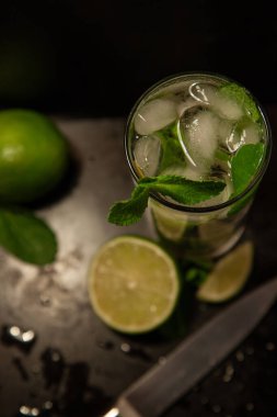 Mojito, siyah arka planda taze nane ve limon.