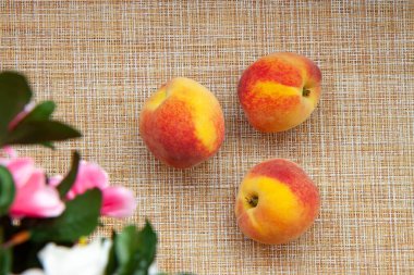 Şeftaliler mutfak peçetesinde, çiçekler bulanık.