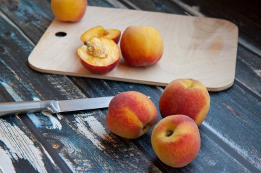 şeftaliler koyu ahşap arka planda, kesme tahtası ve dilimlenmiş şeftali