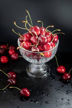 Siyah arka planda camlı kiraz, alçak.