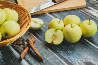 Koyu arkaplanda yeşil elmalar, tarçın